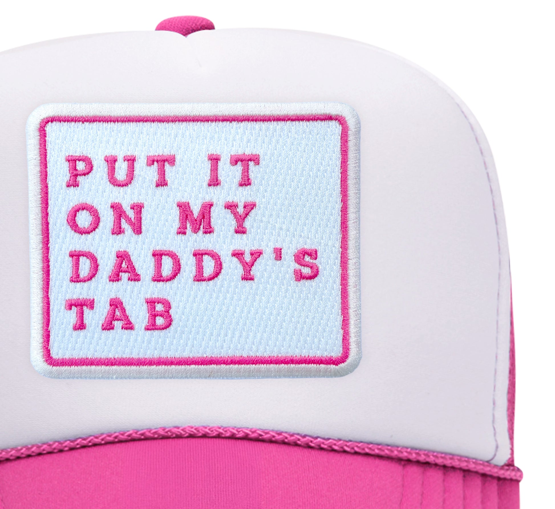 Close-up of the Put It On My Daddy's Tab embroidered patch on a white and hot pink trucker hat