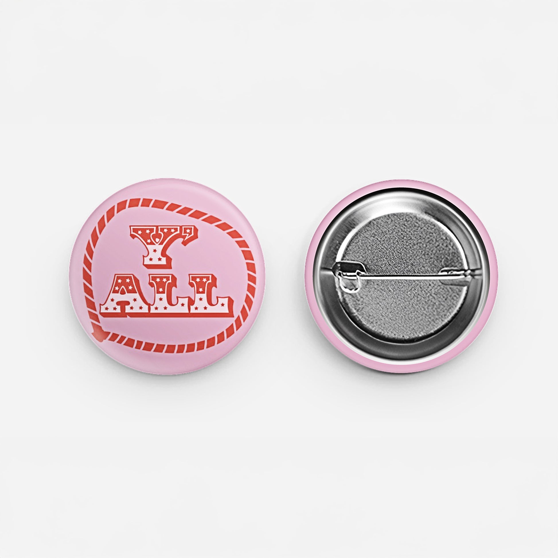Y'ALL pin-back button with red western rope lettering on a pink background