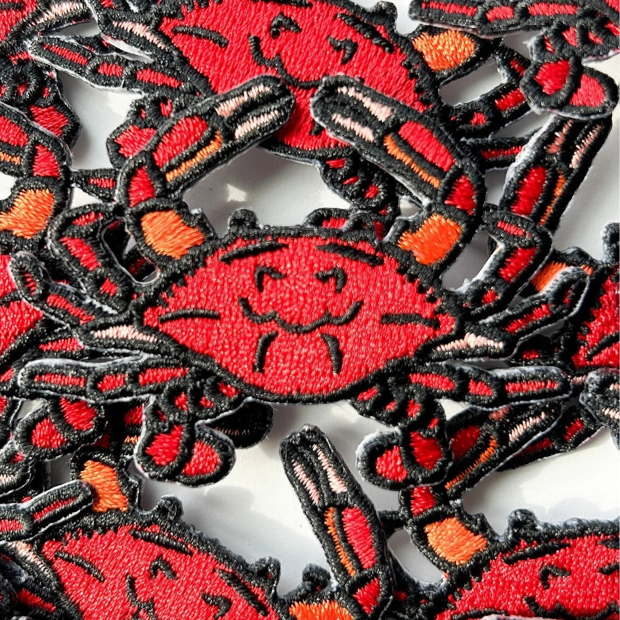 Collection of red and black crab patches on a white background