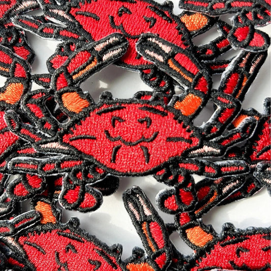 Collection of red and black crab patches on a white background